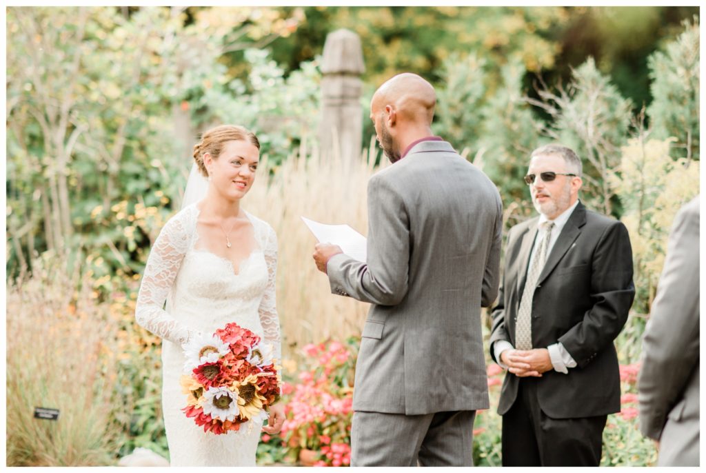 An outdoor ceremony for a maroon and gold fall wedding at the Minnesota Landscape Arboretum. Photography by Kayla Lee.