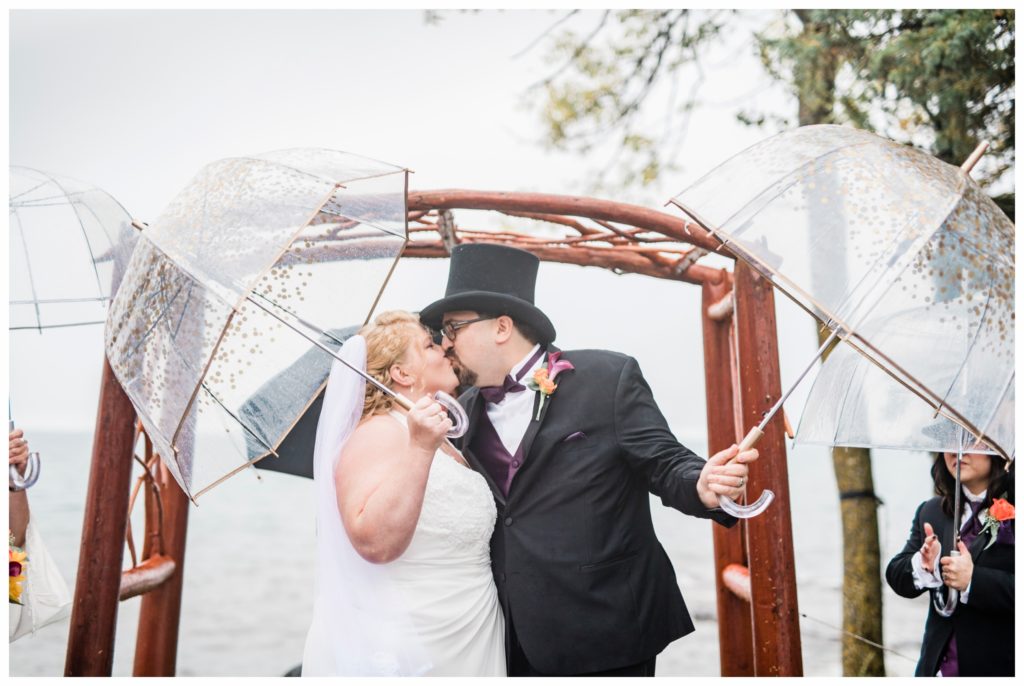 An epic first kiss on a rainy wedding day along Lake Superior. Photo by Kayla Lee.