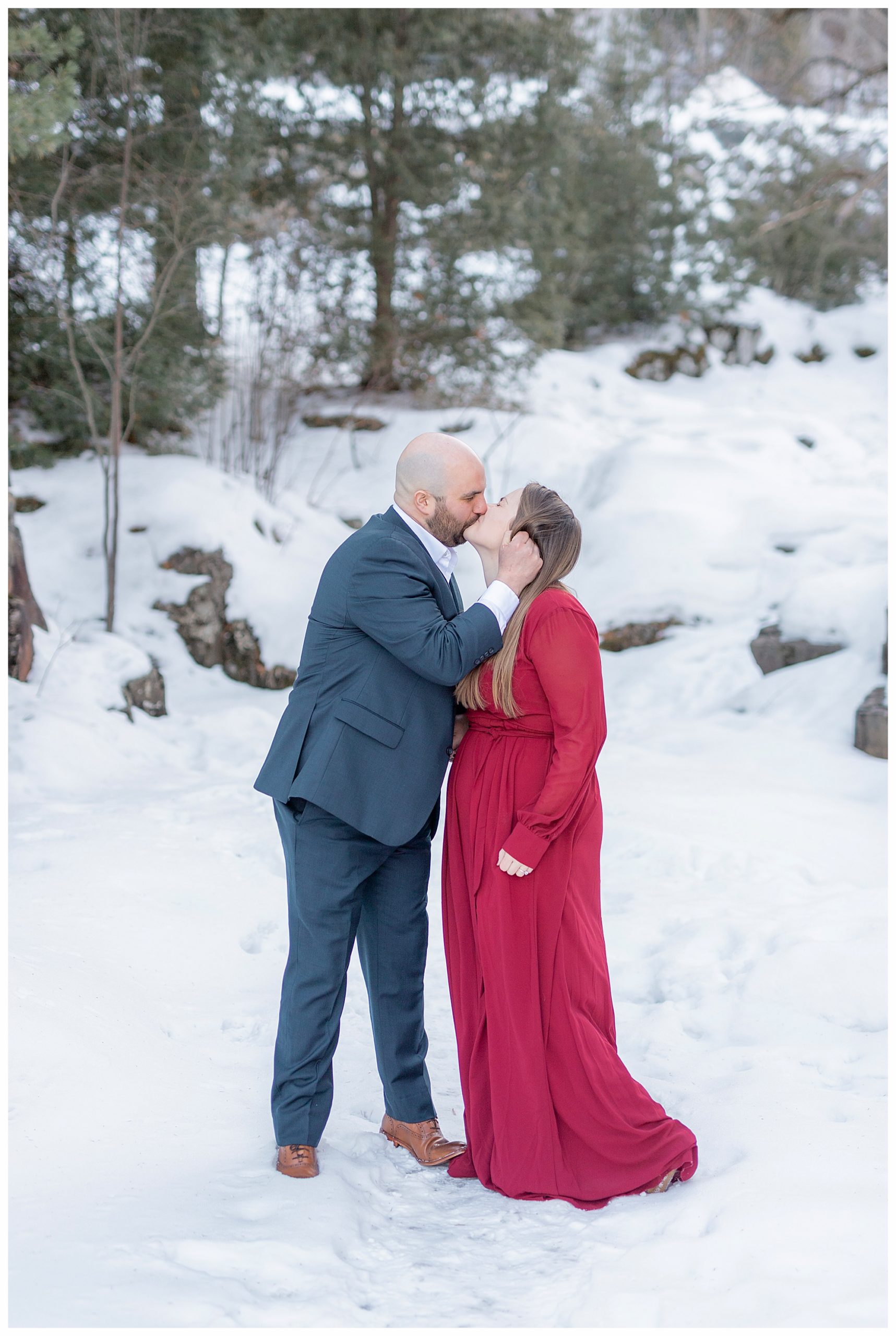 Couple kissing. Maroon dress and navy suit at a Chester Bowl Engagement in Duluth, Minnesota. Photography by Kayla Lee.