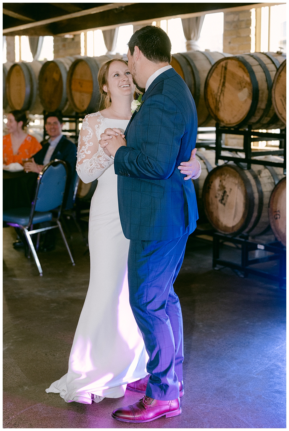 Bride and groom dance in front of barrels in Urban Growler's barrel room. Photo by Kayla Lee.